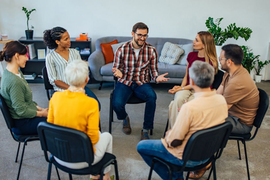 A man speaking in front of a group about what addiction recovery is like