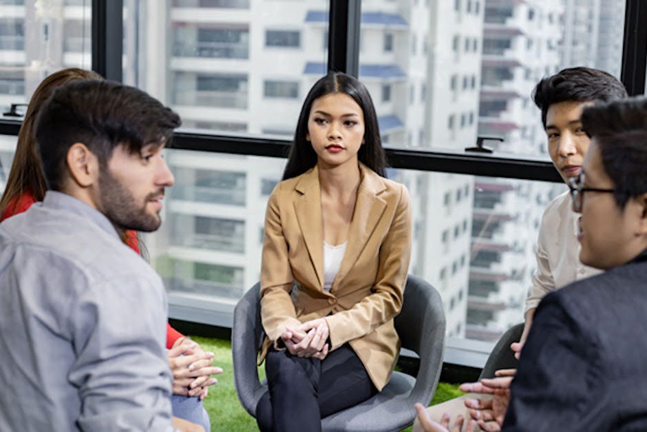 a group of people sitting in circle talking