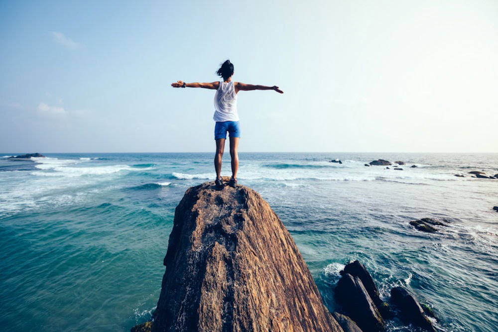 man standing on a rock at the sea