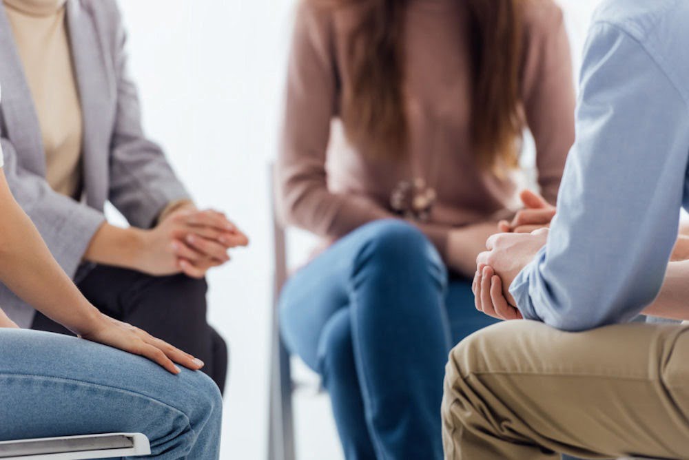 Four people sitting in a circle discussing post acute withdrawal syndrome