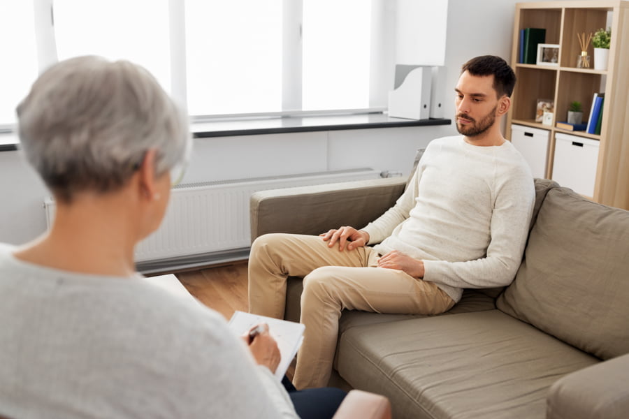 Person speaking with therapist about alcohol-related kidney issues