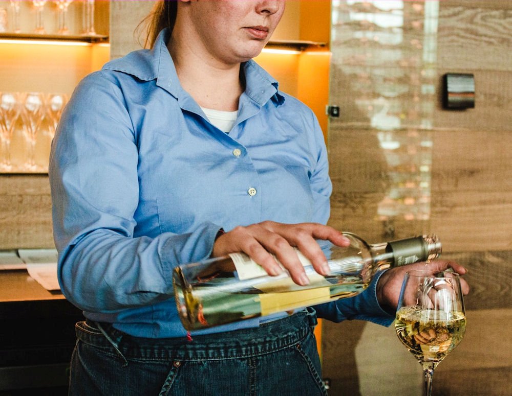 Woman pouring a drink, showing signs of alcohol nose