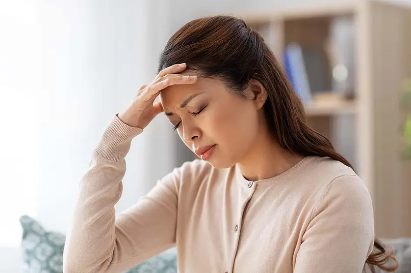 a woman with headache holding her head