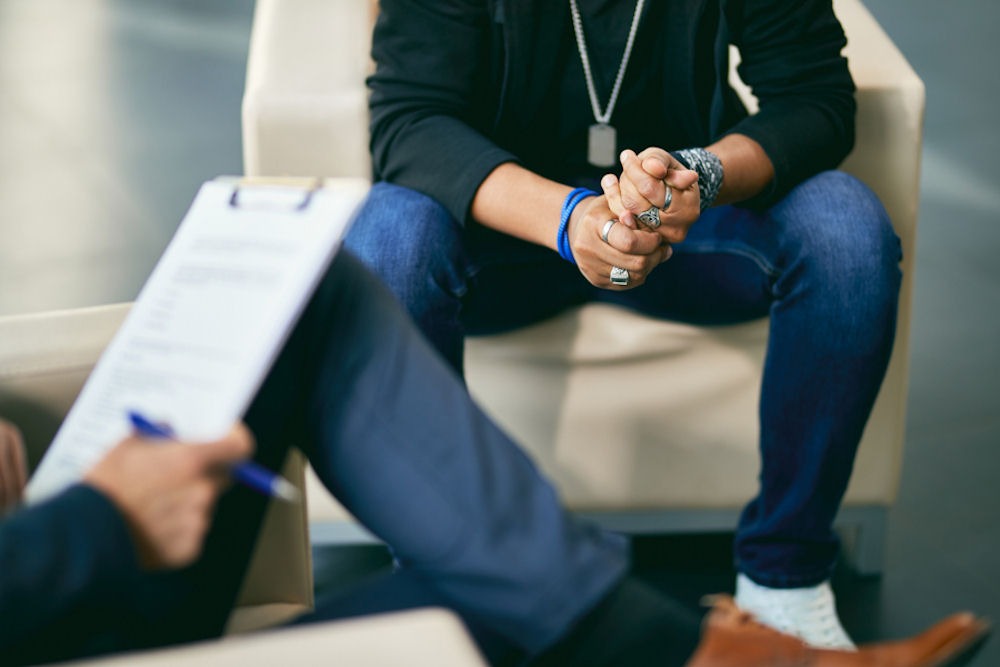 a man sitting on a couch facing his therapist