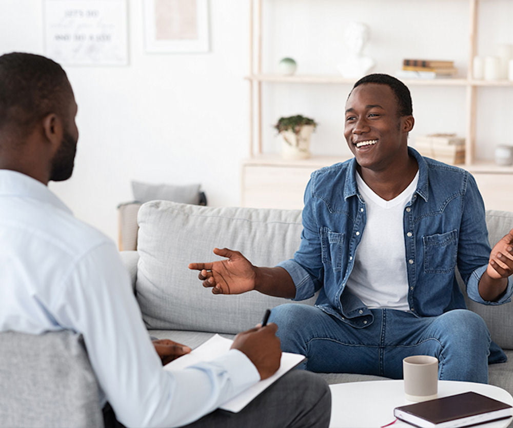 man in individual therapy, smiling while talking with his therapist
