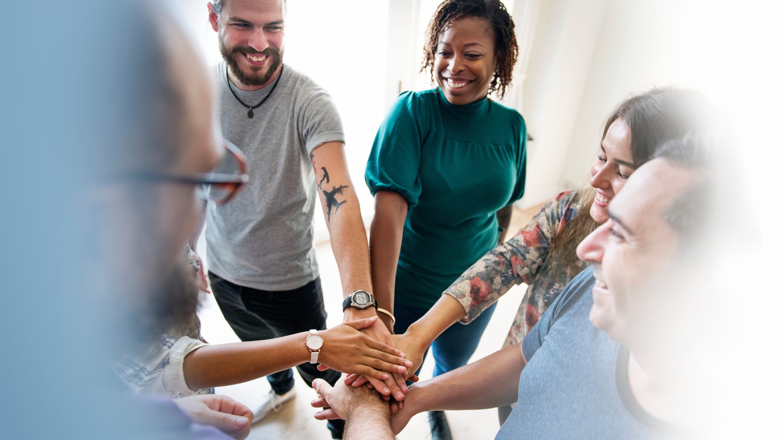 group putting hands together in recovery