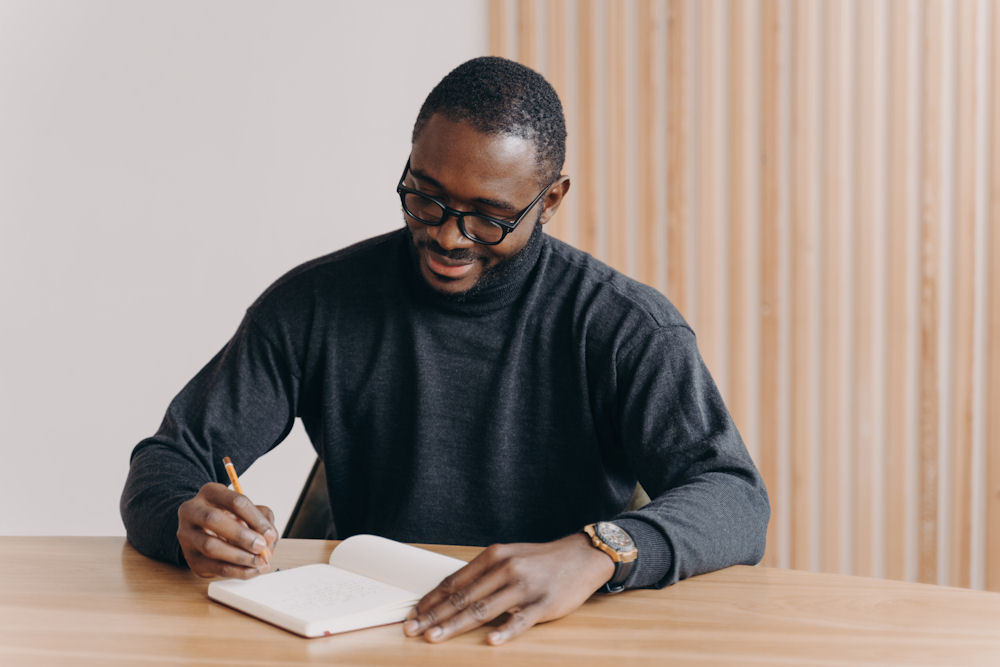 Man journaling in recovery while sitting at a table