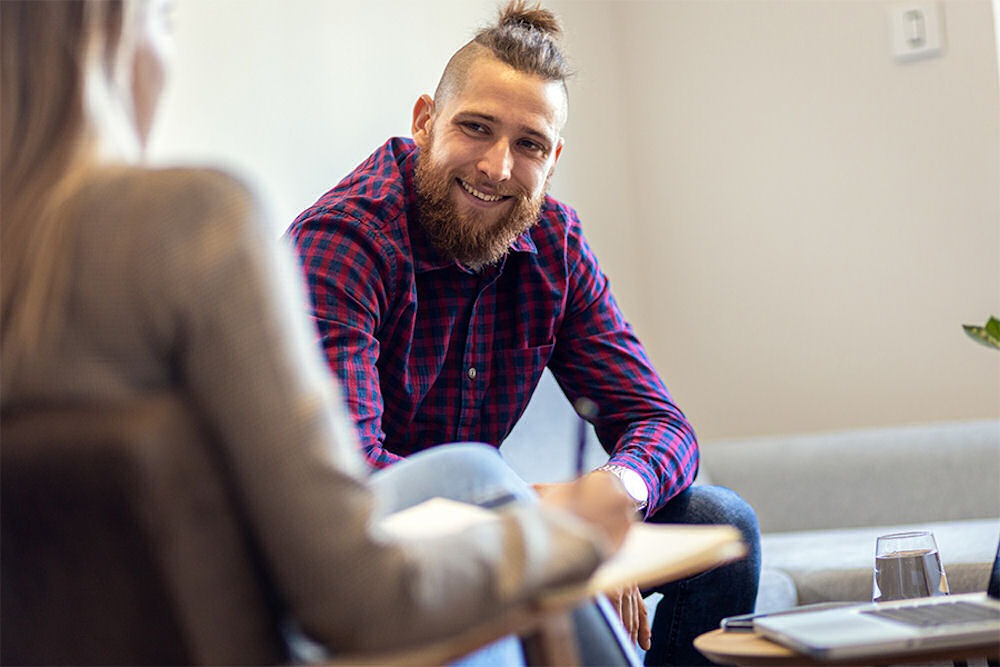 a man smiling in therapy for behavioral health 