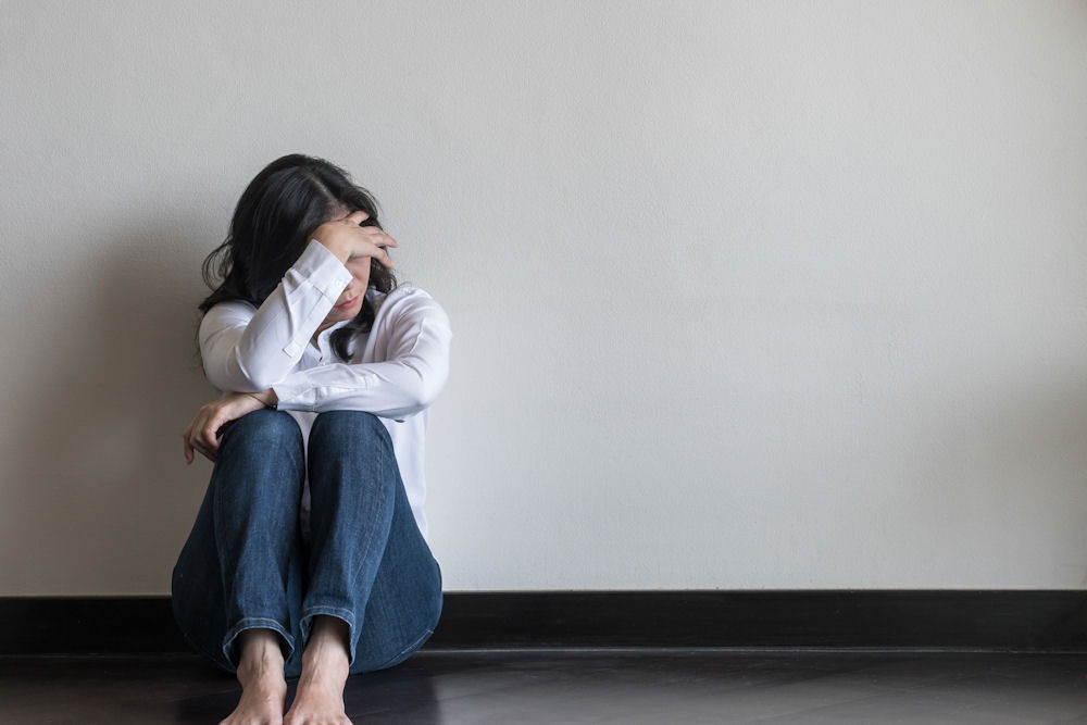 a woman staring at floor head down
