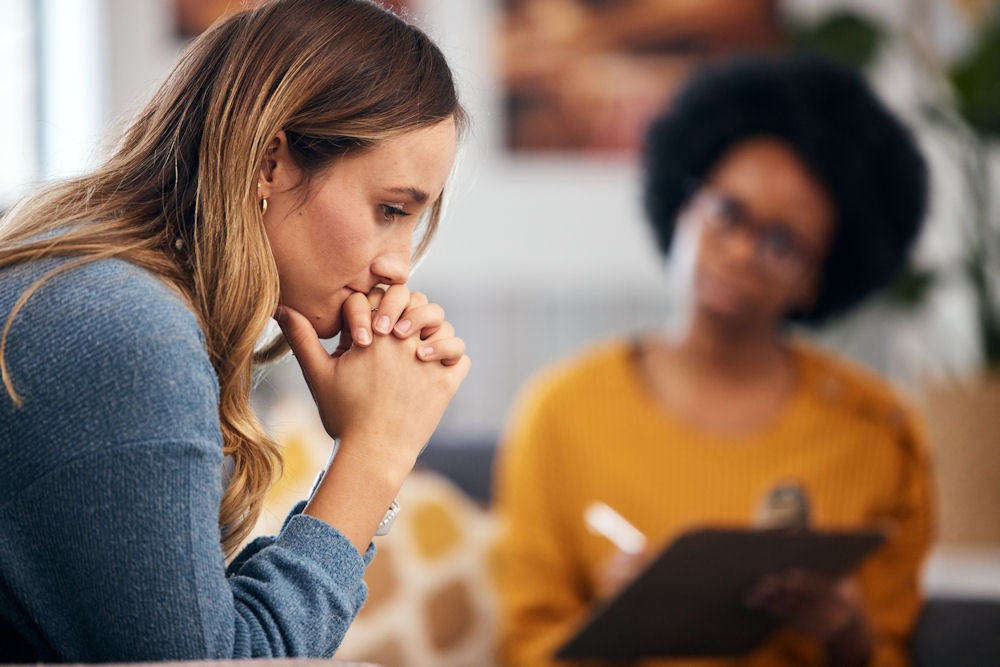 a woman sitting down in thought at therapy