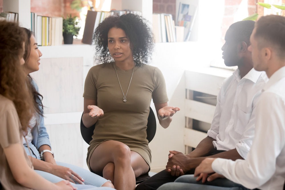 a woman speaking in group therapy