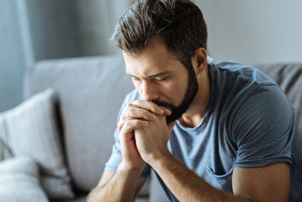 a man with eyes closed praying