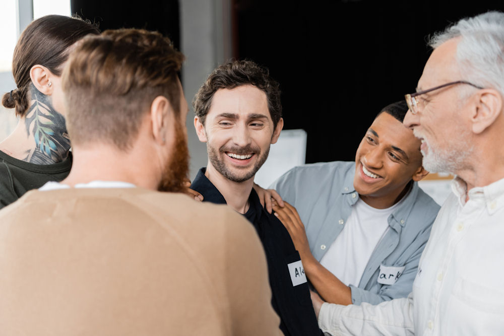 a-man-smiling-in-group-therapy