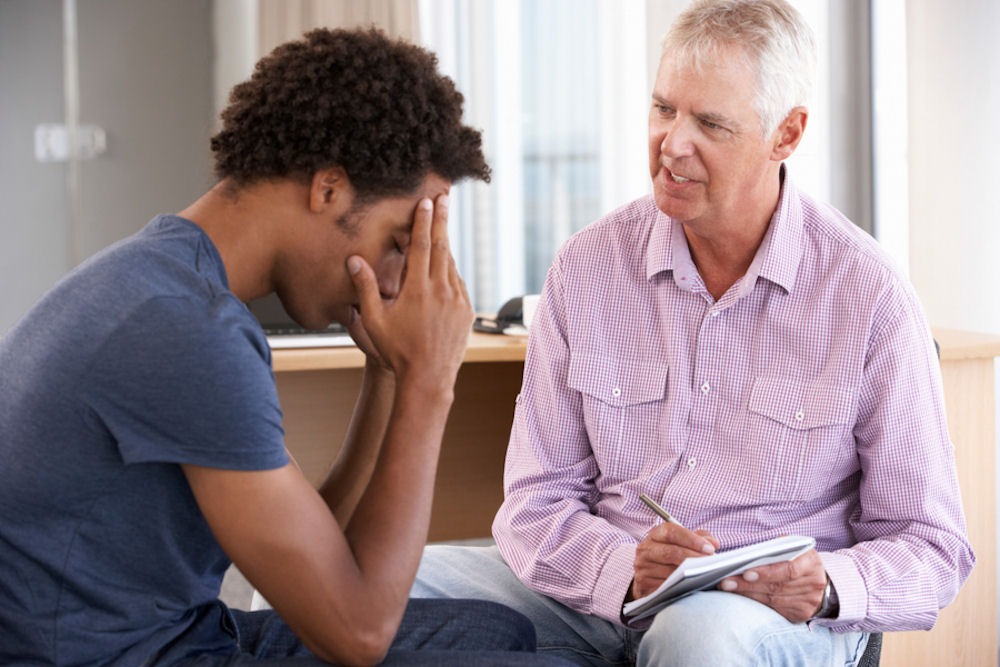 a man covering his face in a therapy session