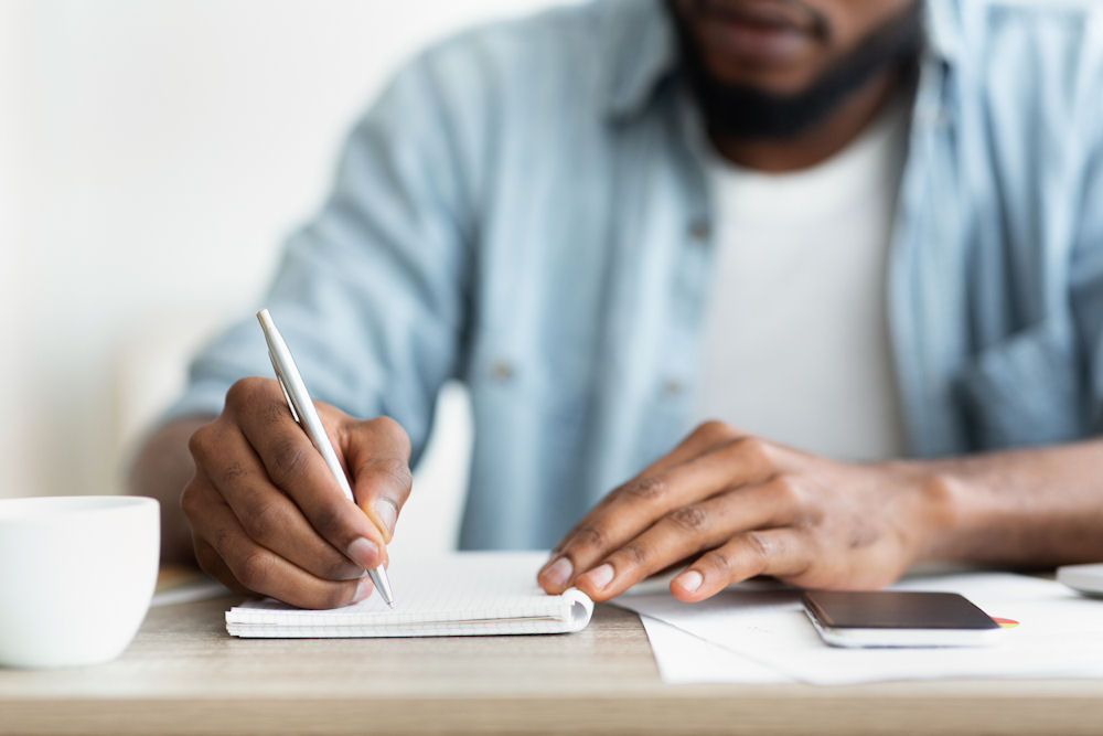 Man taking notes on ways to improve mental health and well-being