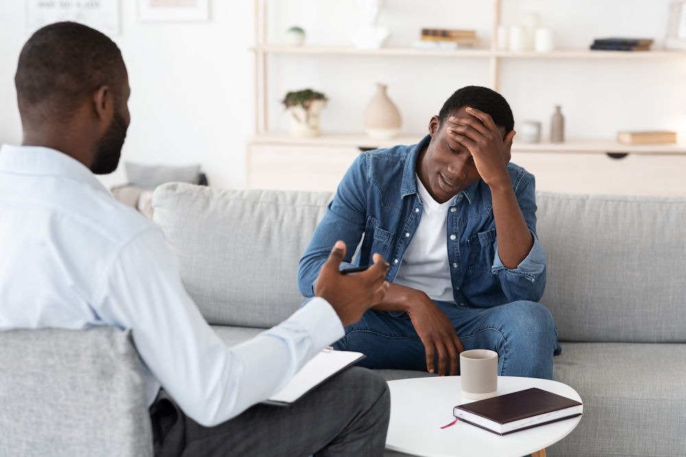 a man with hand on head in therapy