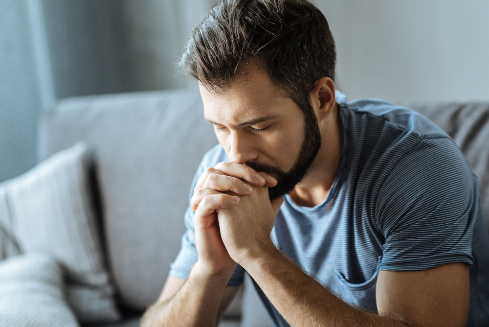 man praying for relief, struggling with depression after using kratom.