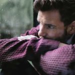 man staring out window, appearing depressed after using kratom, feeling low.