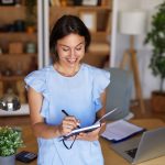 a-woman-smiling-writing-in-journal