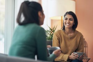 women-smiling-with-a-cup-of-coffee