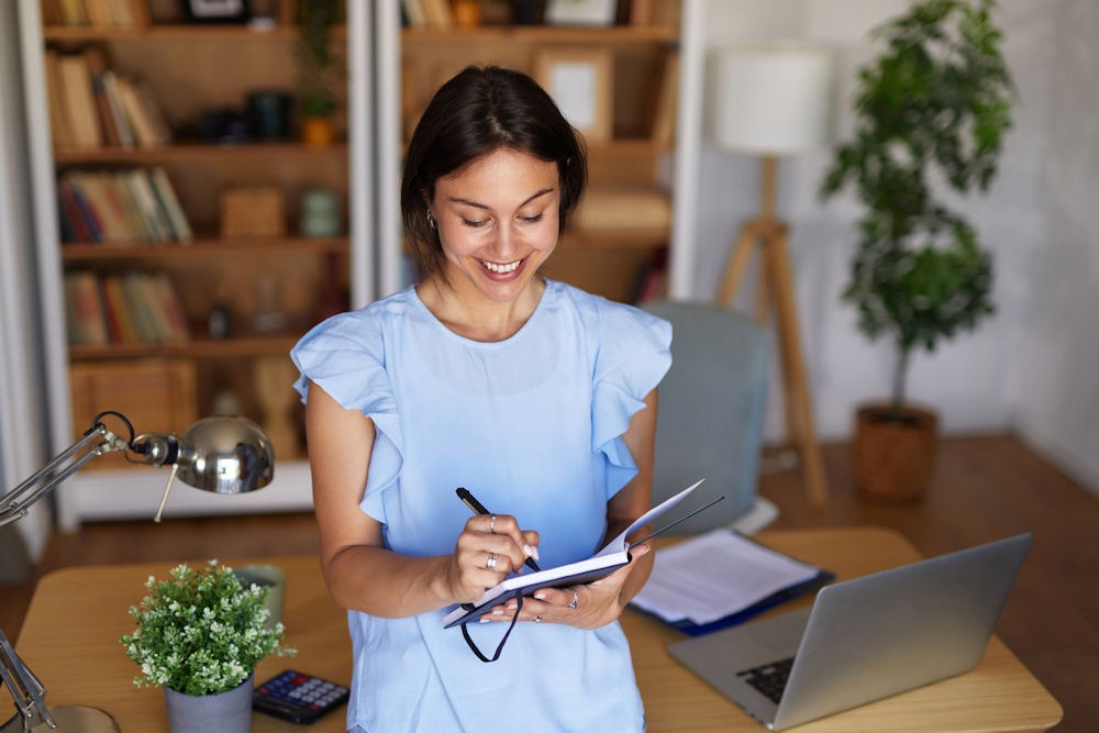 Woman setting personal goals and building resilience in recovery through reflection, planning, and healthy routines.