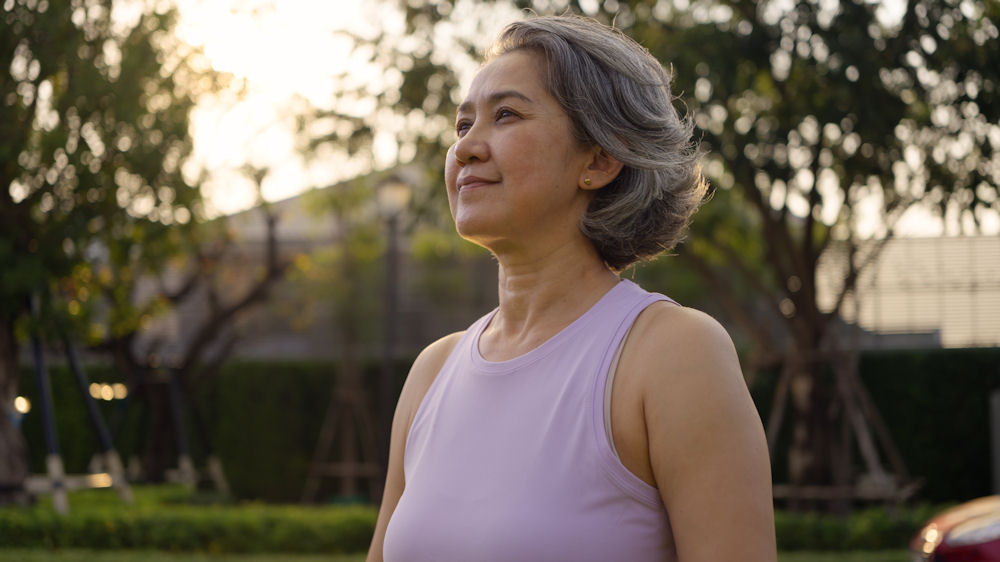 Middle-aged woman practicing self-care during a peaceful walk outdoors, reflecting resilience and emotional balance amid depression and menopause.
