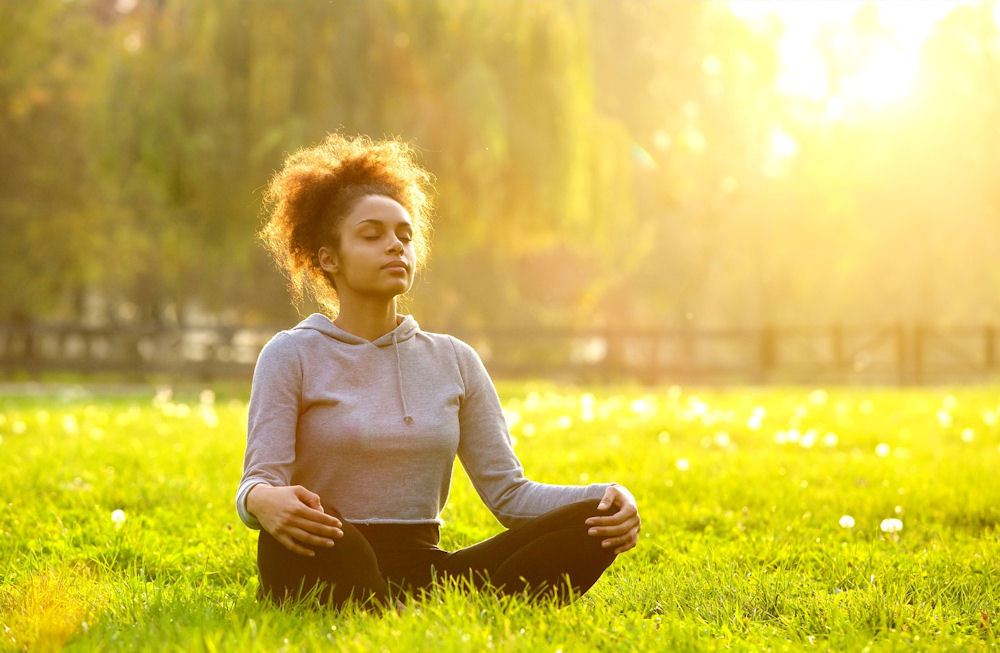 a-woman-meditating-in-the-grass