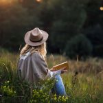 a-woman-sitting-in-the-grass-reading