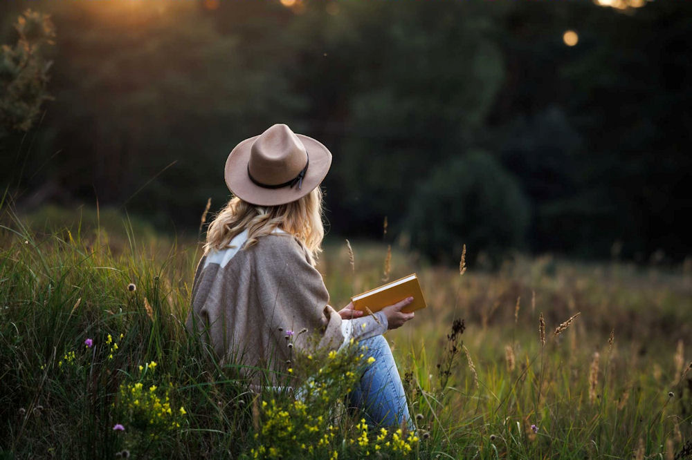 a-woman-sitting-in-the-grass-reading