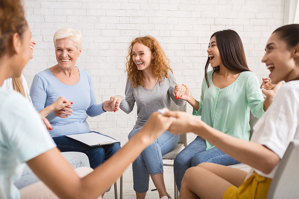 womens-rehab-program-portland-oregon a group of women holding hands in therapy